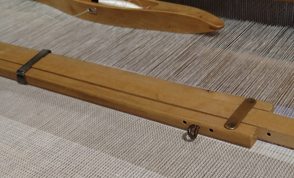 the emerging textile in progress on the loom